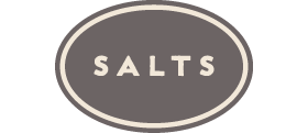 Salts category logo: The word SALTS, centered in a gray oval with a thin, inset cream colored border.