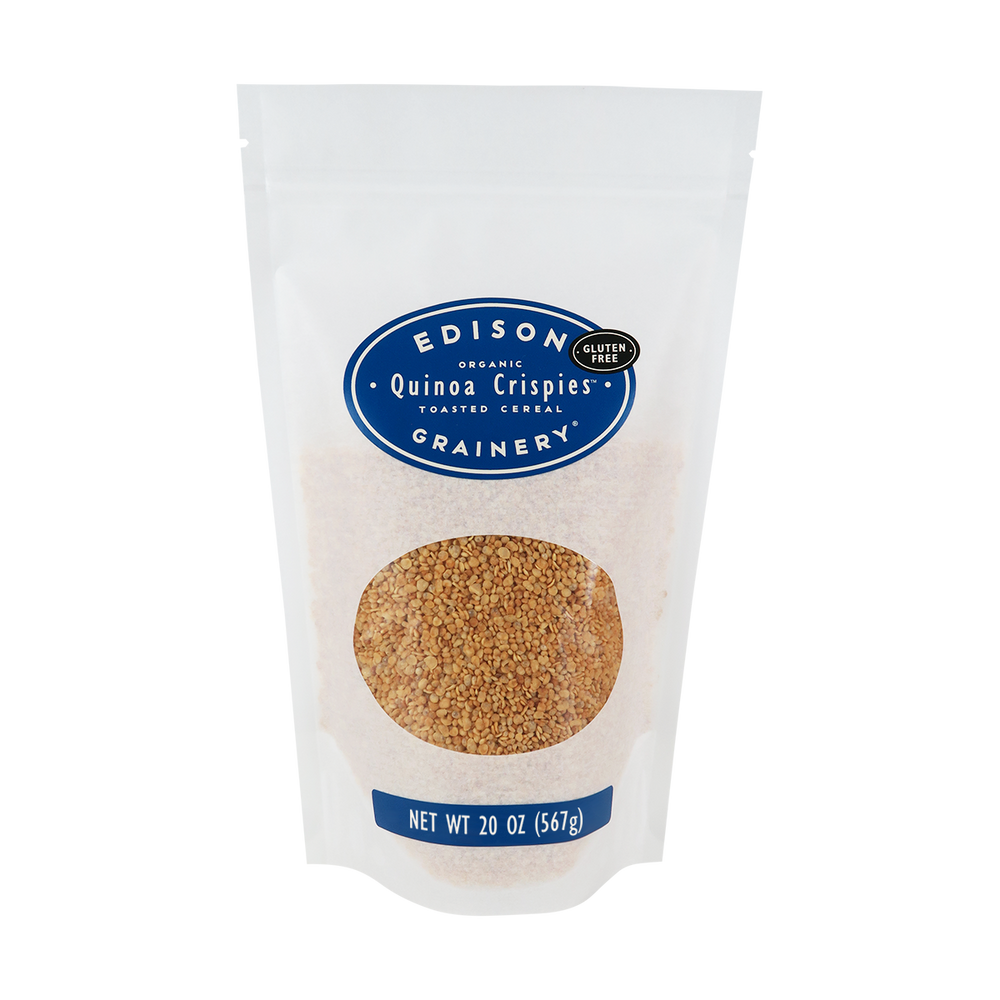 A 20 oz bag of Organic Quinoa Crispies standing upright in a bio-degradable bag. A royal blue oval label, bearing the product name sits above an oval viewing window revealing the product.