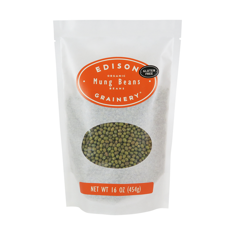 A 16 oz bag of Organic Mung Beans standing upright in a bio-degradable bag. An orange oval label, bearing the product name sits above an oval viewing window revealing the product.
