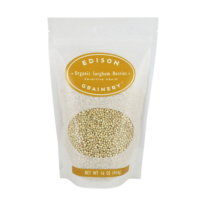 A 16 oz bag of Organic Golden Quinoa standing upright in a bio-degradable bag. A golden yellow oval label, bearing the product name sits above an oval viewing window revealing the product.
