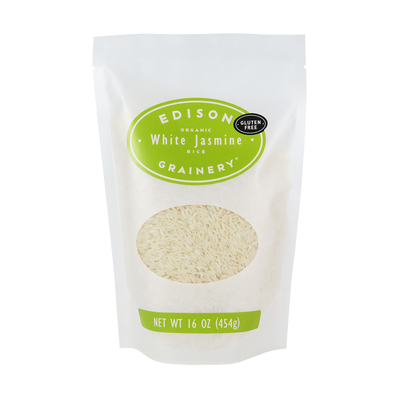 A 16 oz bag of Organic White Jasmine Rice standing upright in a bio-degradable bag. A lime-green oval label, bearing the product name sits above an oval viewing window revealing the product.