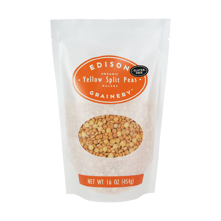 A 16 oz bag of Organic Yellow Split Peas standing upright in a bio-degradable bag. An orange oval label, bearing the product name sits above an oval viewing window revealing the product.